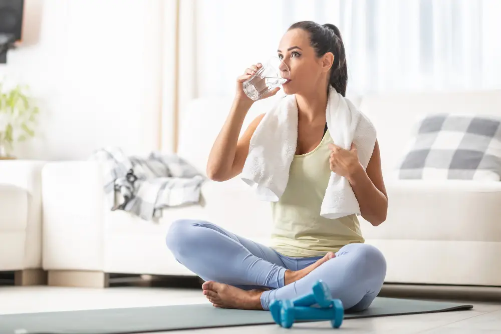 Woman drinks water after exercise