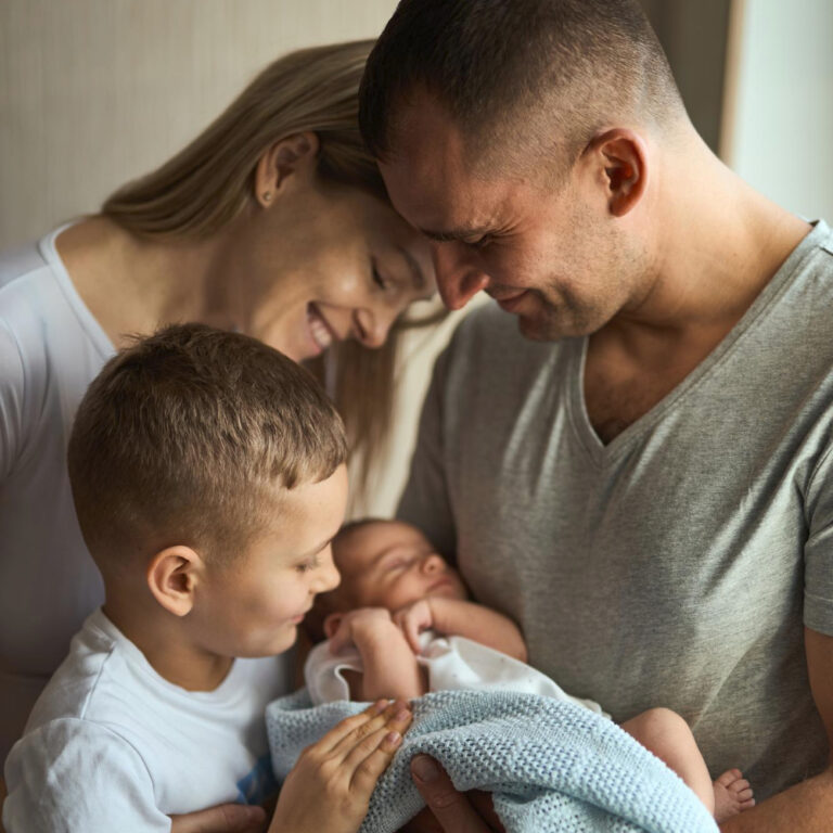 father mother holding newborn daughter arms older brother stands looks with love family values e1704739584920