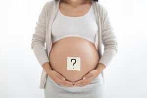 pregnant woman with paper sticker with question mark belly